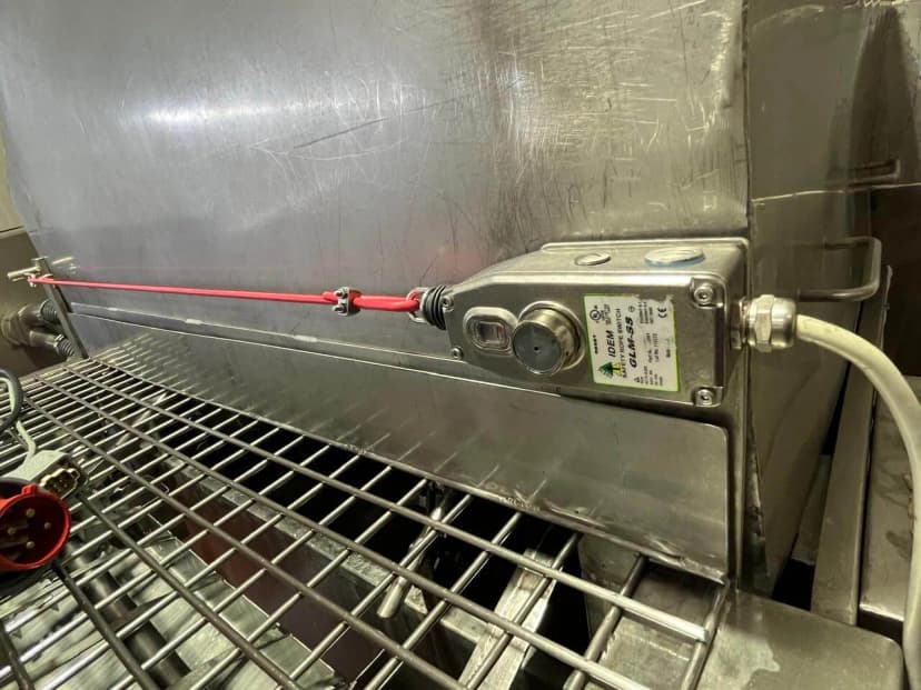 Chave de emergência acionada por cabo instalada em máquina de aço inox de processamento de alimentos