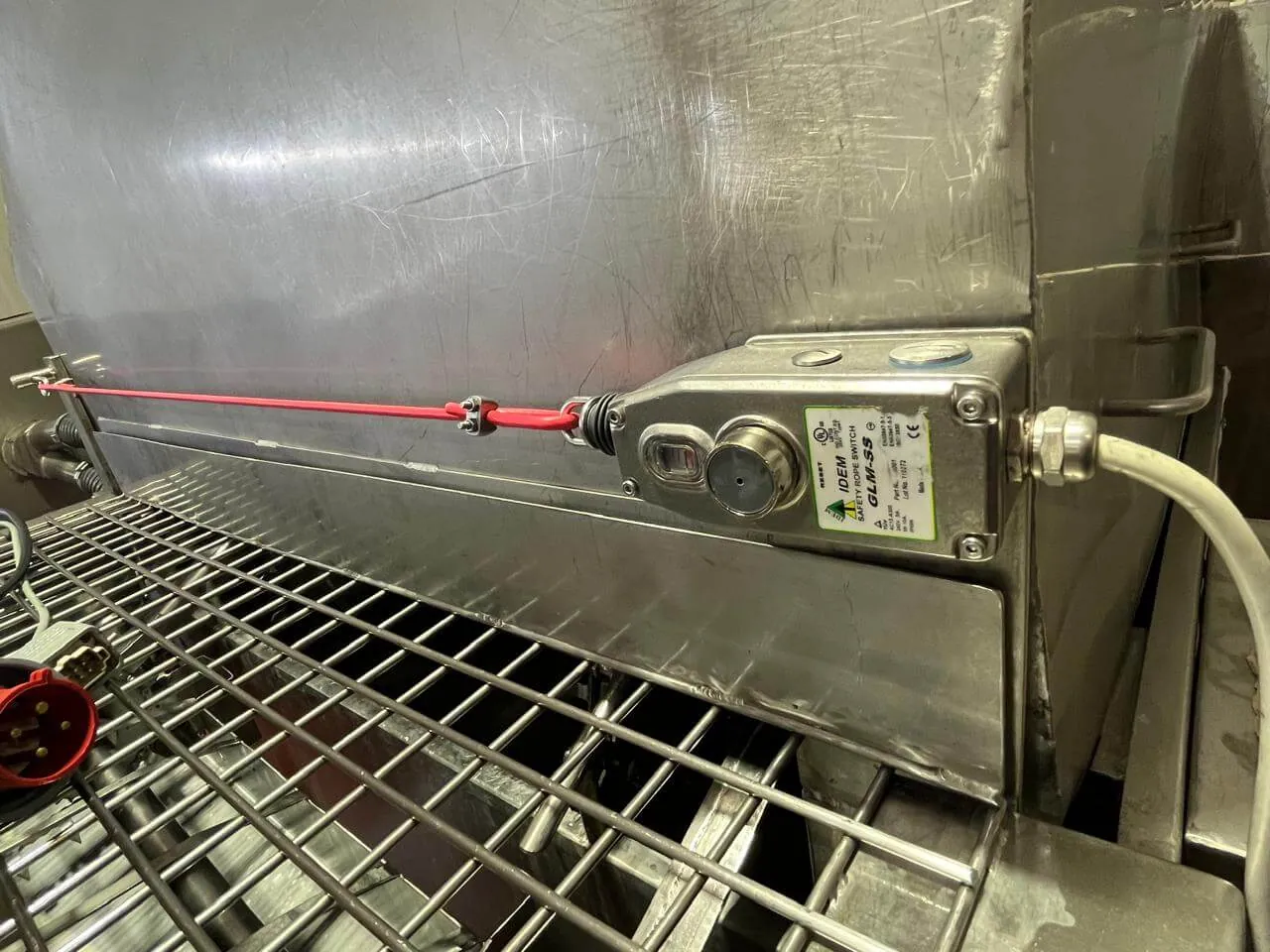 Chave de emergência acionada por cabo instalada em máquina de aço inox de processamento de alimentos